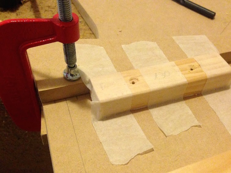 Pine strips being held to one of the lateral boards using paper tape