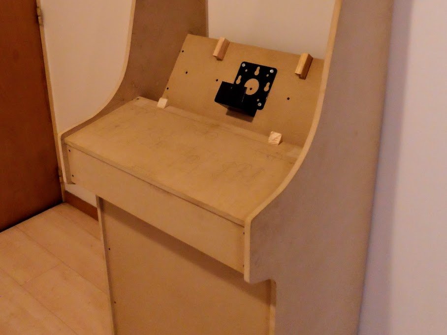 The wooden cabinet empty. It has 4 strips that allow the monitor to be held in place