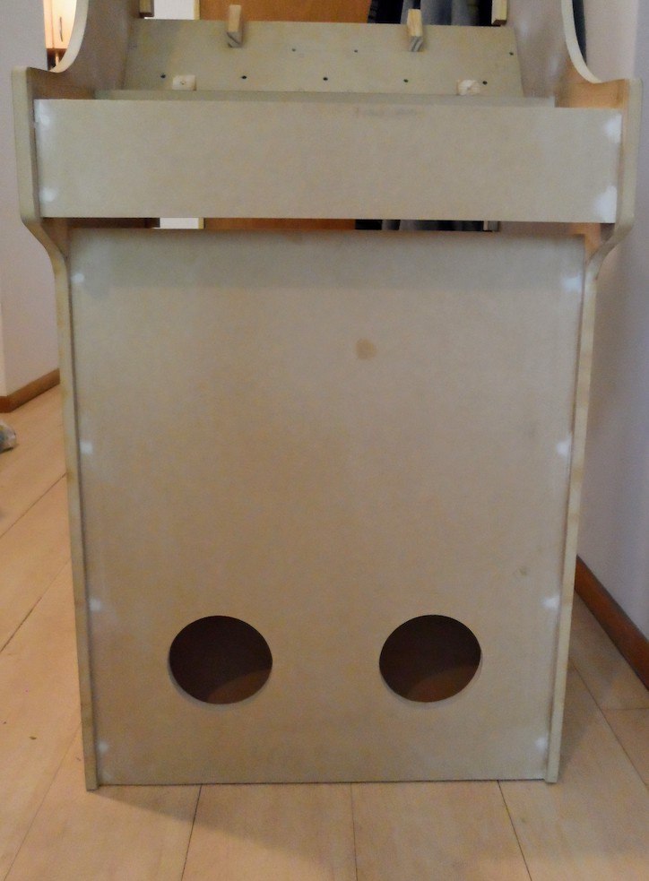 The arcade cabinet with all the screws covered in putty